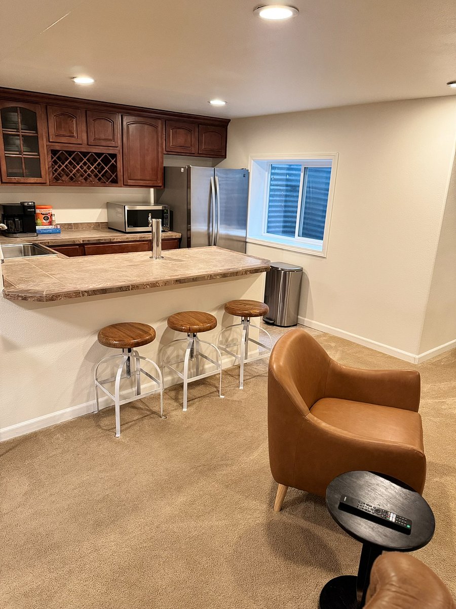 Basement wet bar with Kenmore (refrigerator with freezer) and Panasonic microwave and counter seating with barstools