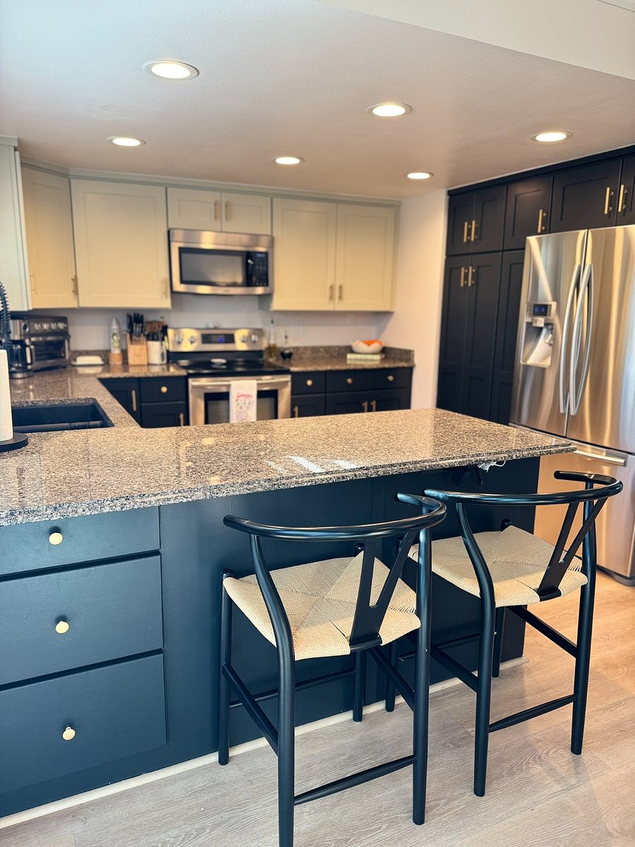 Samsung kitchen appliances (refrigerator, oven and microwave) and Frigidaire dishwasher. Additional dining seating with barstools at counter.