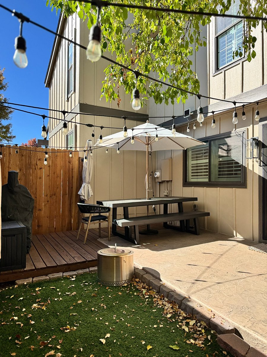Private, fenced patio designed for effortless entertaining and relaxation. Features a Solo Stove fire pit, Traeger grill, string lights, and a shaded picnic table for al fresco dining or morning coffee.