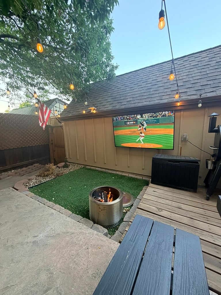 Private, fenced patio designed for effortless entertaining and relaxation. Features a Solo Stove fire pit, Traeger grill, string lights, and a shaded picnic table for al fresco dining or morning coffee.