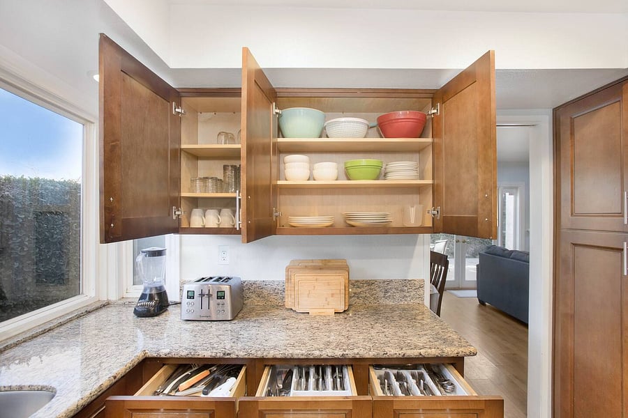 The kitchen is well stocked with cookware, utensils, silverware, and glassware.