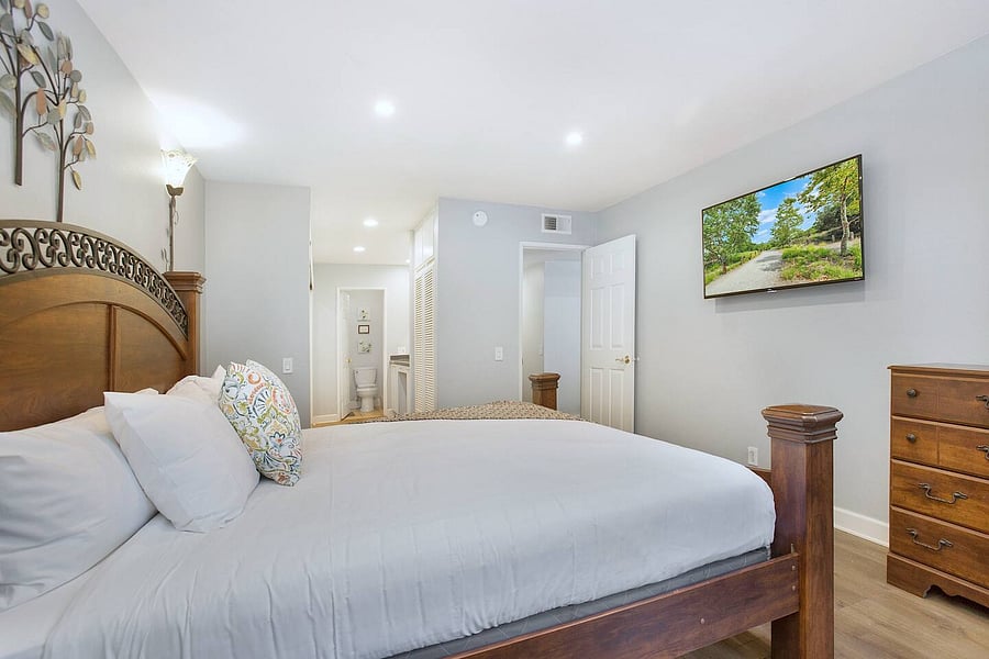 Make yourself at home in this comfortable master bedroom featuring a king-size bed and a Smart TV, perfect for enjoying a peaceful night's rest and cozy entertainment.