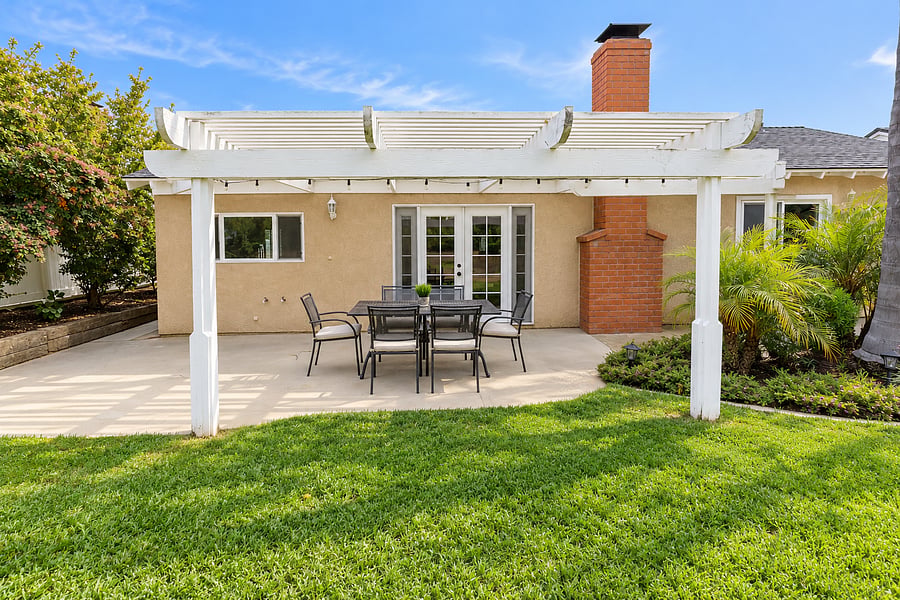 Outdoor seating area overlooking a gorgeous, lush green backyard, perfect for relaxing and enjoying the outdoors.