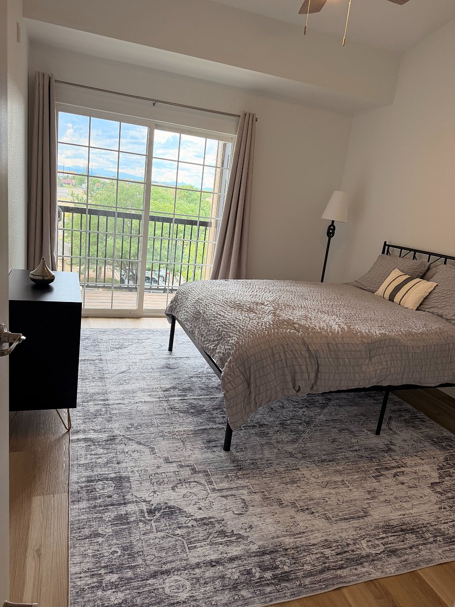 main bedroom with queen bed and blackout curtains