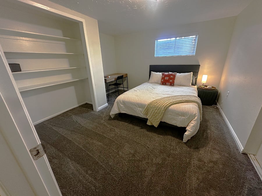 Bedroom 2 with queen-size bed, workspace/desk, and ample storage.