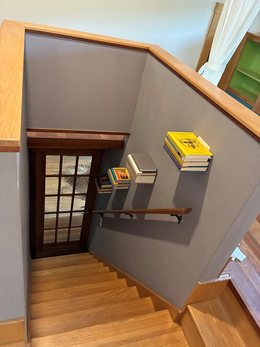 Stairwell from above with floating bookshelves.