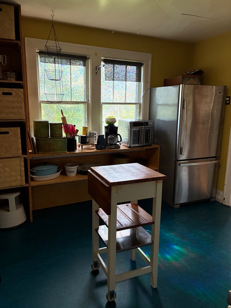 Kaleidoscopic rainbow light brightens the kitchen, complete with bottom-drawer freezer refrigerator, toaster oven/air fryer combo, and coffee maker.