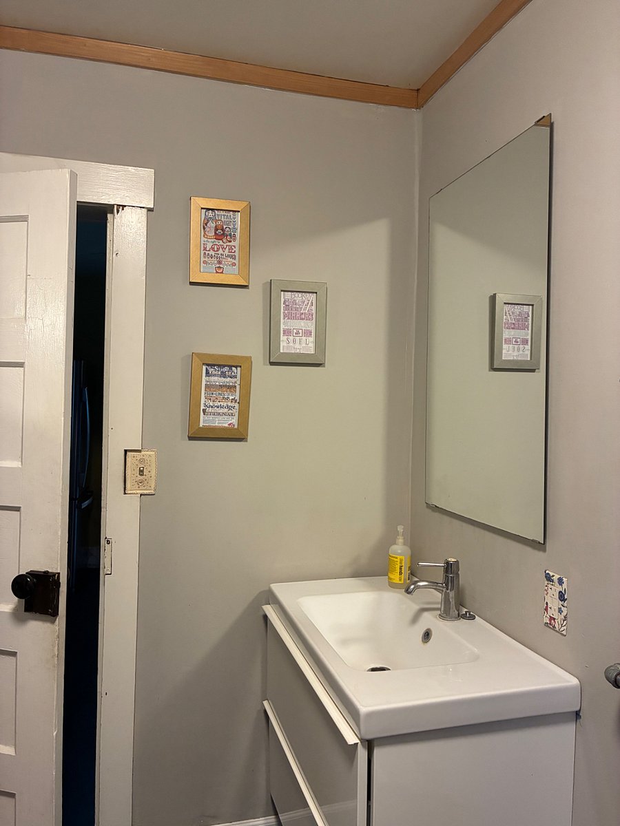 Full bath with under-sink storage, mirror, and outlet.