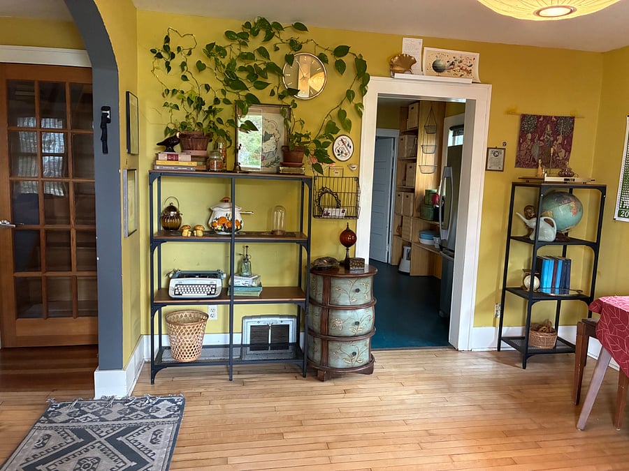 Dining room shelving, with view of door to upstairs bedrooms and doorway to kitchen.