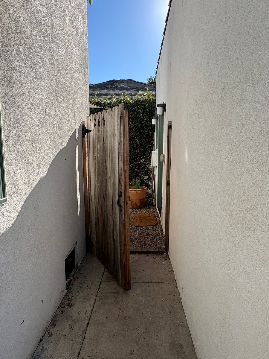 Private entrance to studio through wooden gate.