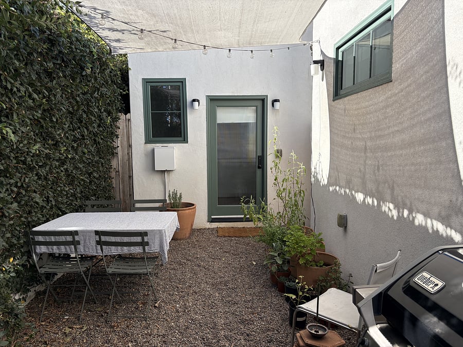 Private entrance (pictured) faces shared patio with table and chairs, gas grill, and washer/dryer.