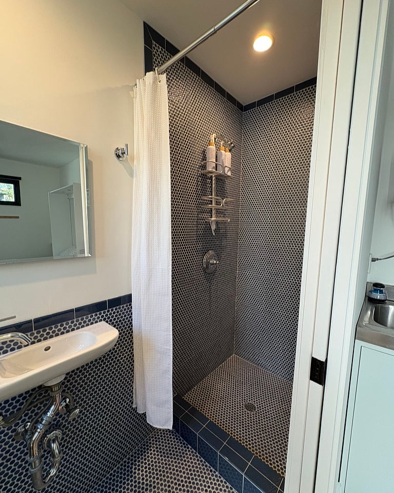 Shower, sink and medicine cabinet. Pocket door separates the bathroom from the rest of the studio.