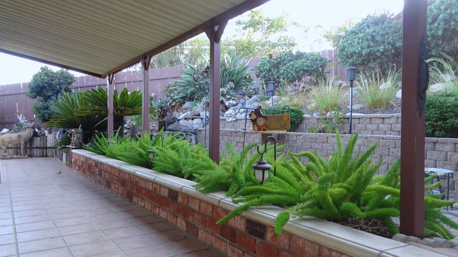 Shaded patio seating in a garden setting is right outside your sliding door.