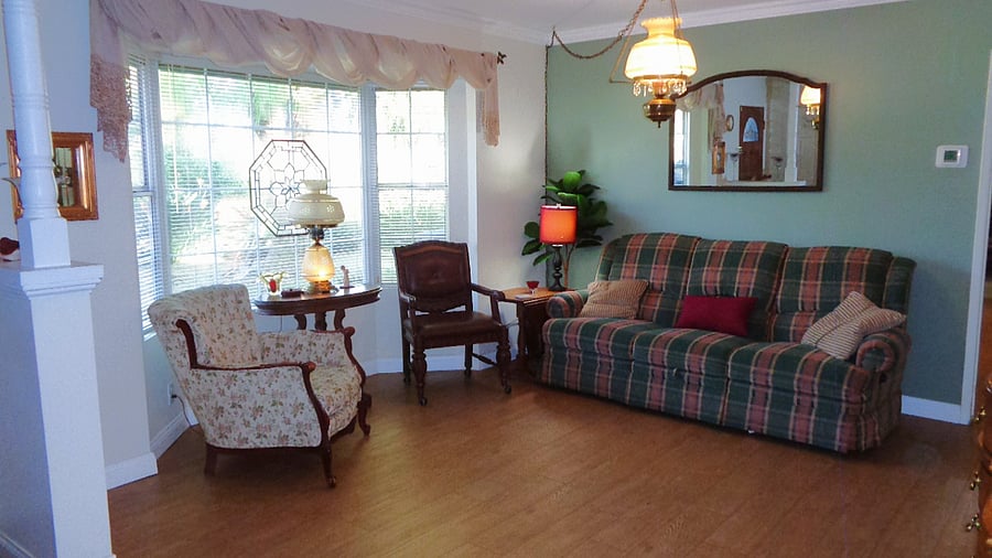 Second lounging area looks out into the willow tree shaded yard with lovely flowers on its border. This room is spacious enough for yoga mats or to be used as a stretching area.