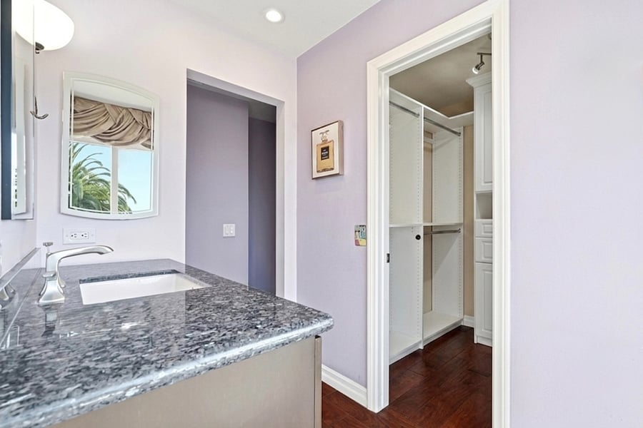 Primary suite with custom walk-in closet and ensuite bathroom with walk-in shower