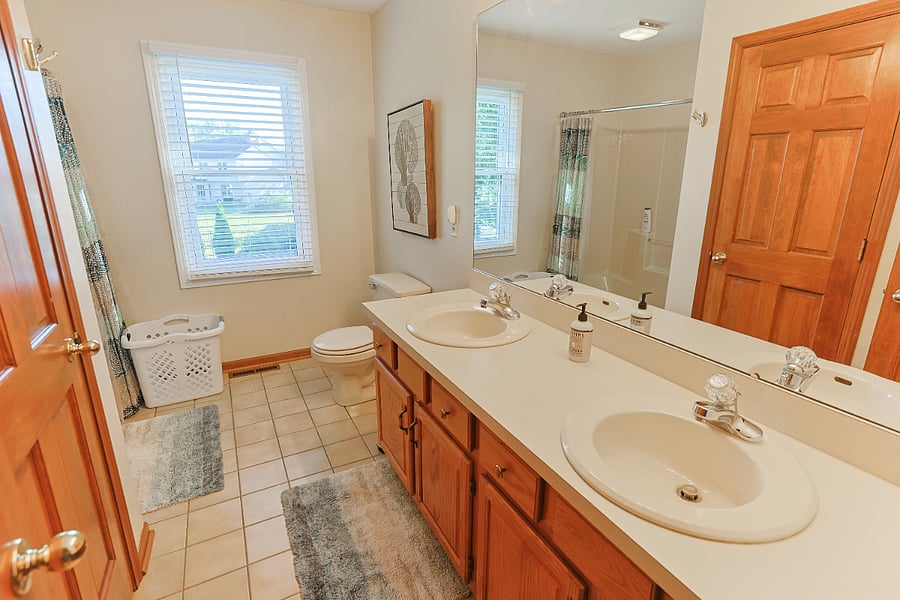 Guest bathroom with double sinks and full bathtub/shower combo