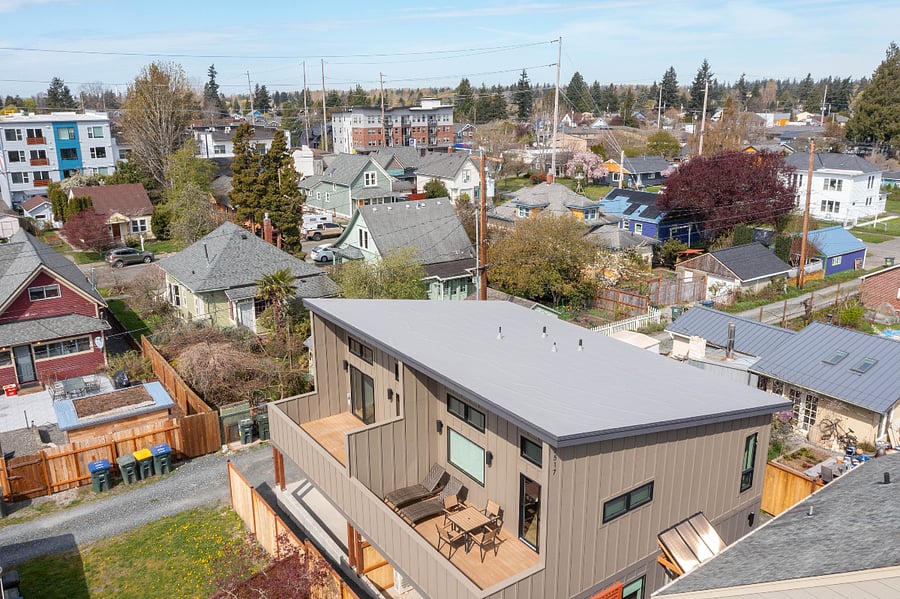 Unit listed has outdoor furniture. Aerial view. Entrance to the home at ground level.