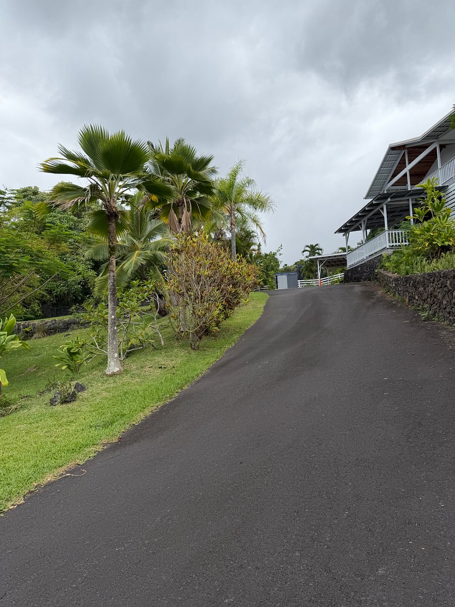 Driveway wraps around back of house with two 2-car carports