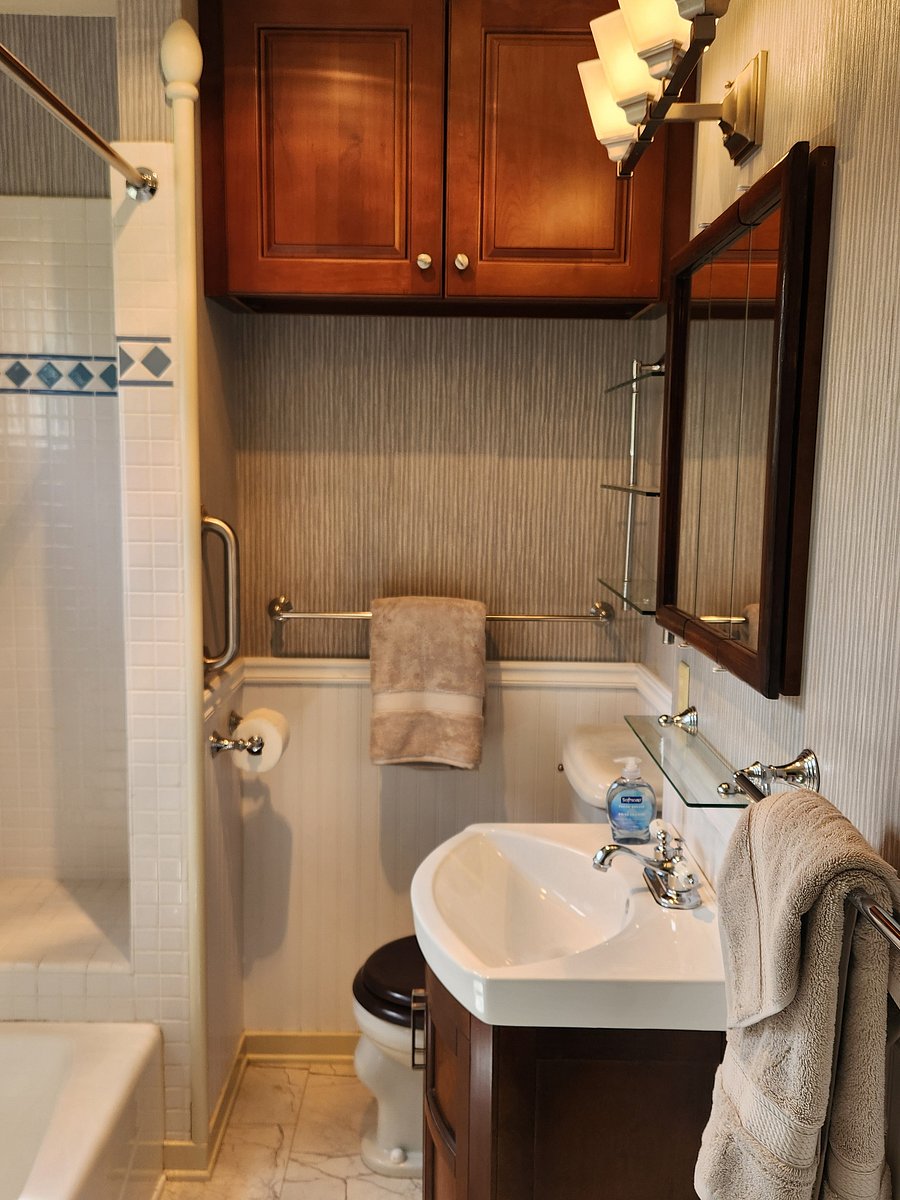 Full-size bathtub, 3-door medicine cabinet, sink cabinet and a large wall-mounted linen storage cabinet.