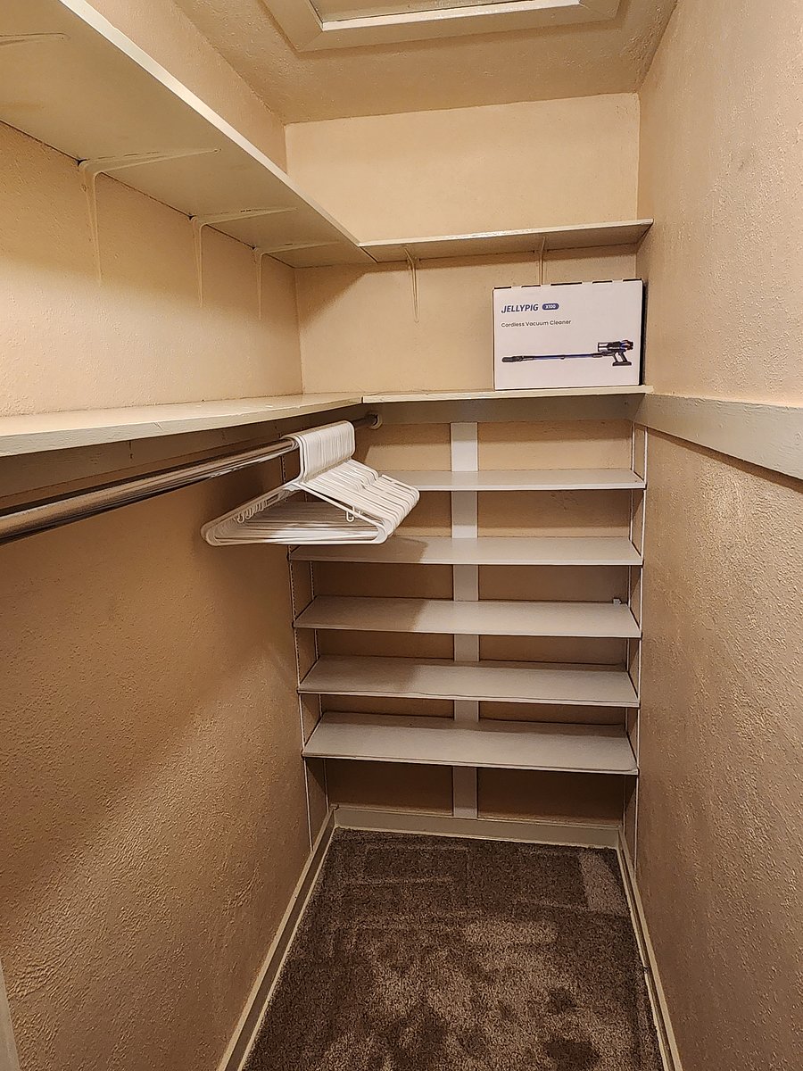 Walk-in closet with lots of shelves for sweaters and shoes.