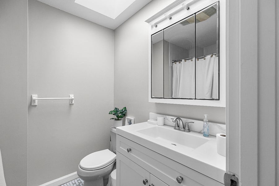 Clean, bright full bathroom featuring a tub/shower combo and fresh towel sets provided.