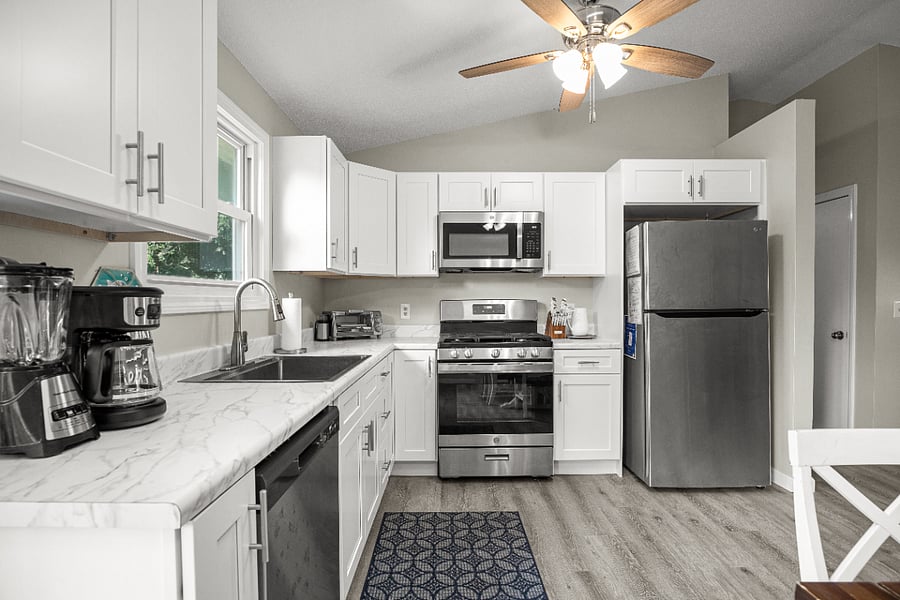 Fully equipped kitchen with full-sized stainless steel appliances, dishwasher, and microwave for easy meal prep.