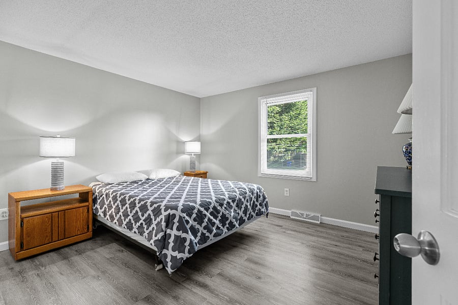 Primary bedroom with a plush queen mattress, crisp linens, and integrated blackout curtains for day-sleeping (not in pic, apologies)