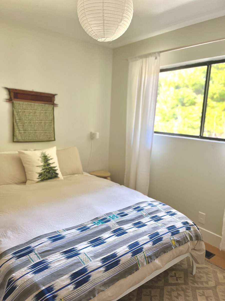 Second bedroom, queen sized bed overlooking the backyard and redwood tree.
