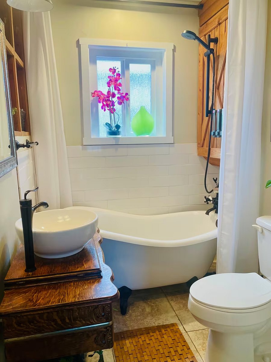 Bathroom with claw-foot fiberglass tub and antique vanity.