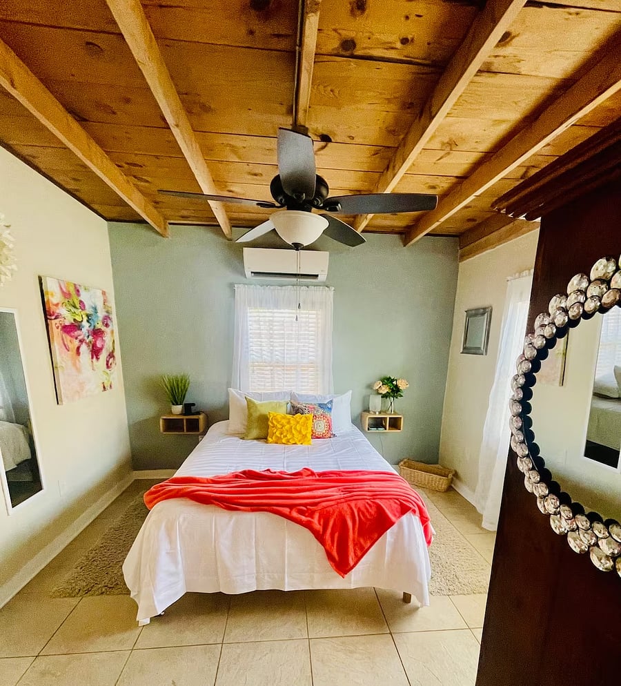 Bedroom windows offer an airy atmosphere with blinds for privacy.
