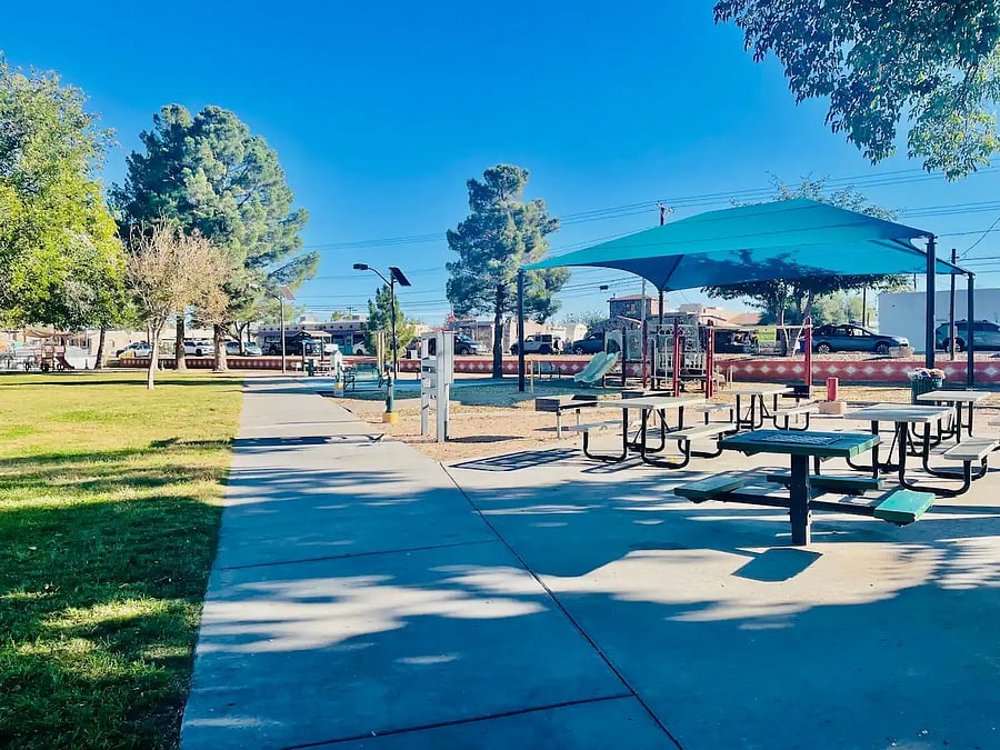 Outdoor playground with a neighborhood restaurant, coffee house and ice cream shop surrounding the park.