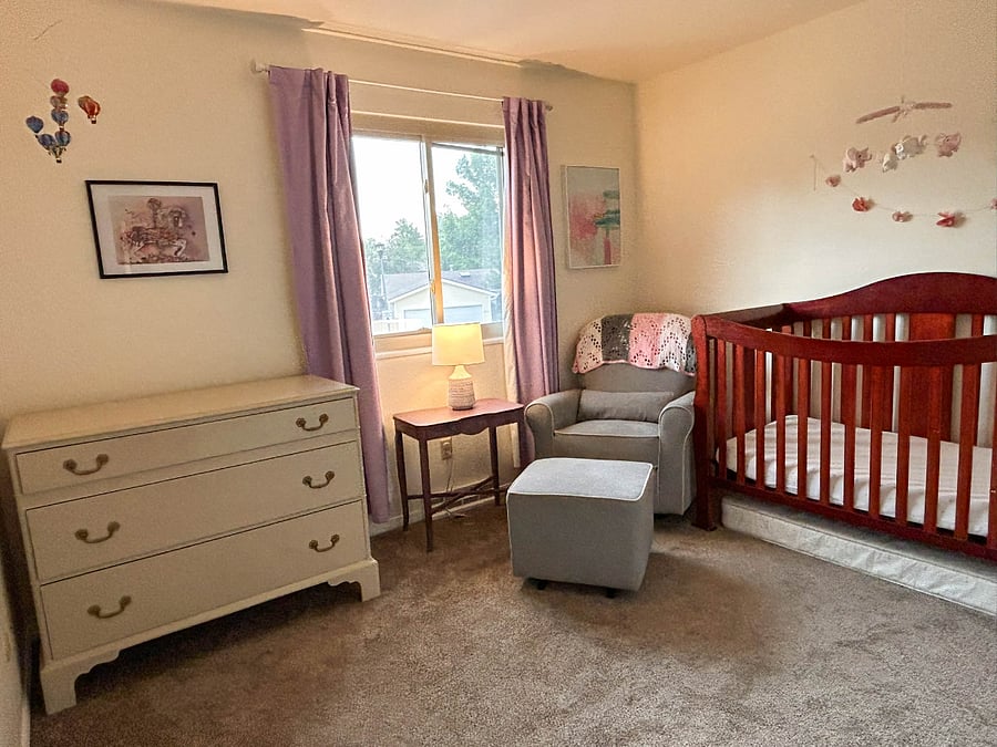 Baby room with crib, dresser, and glider/recliner.