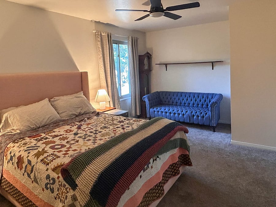 Master bedroom with sitting nook and storage closet next to couch.