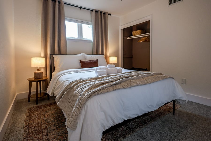 Cozy queen Bedroom 2 with soft linens, stylish decor, and plenty of storage for a comfortable stay.