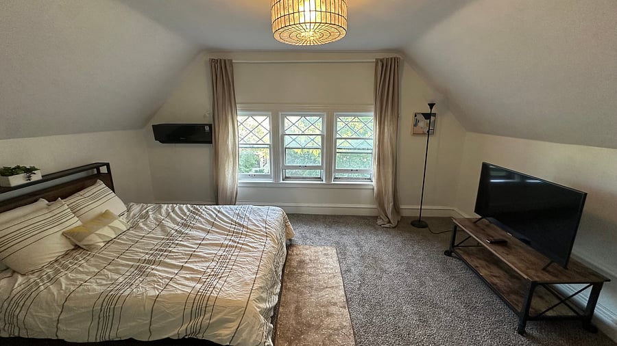 Bedroom with original diamond-pane windows and smart TV