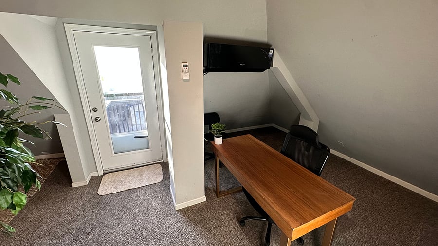 Office with desk and door to the private deck