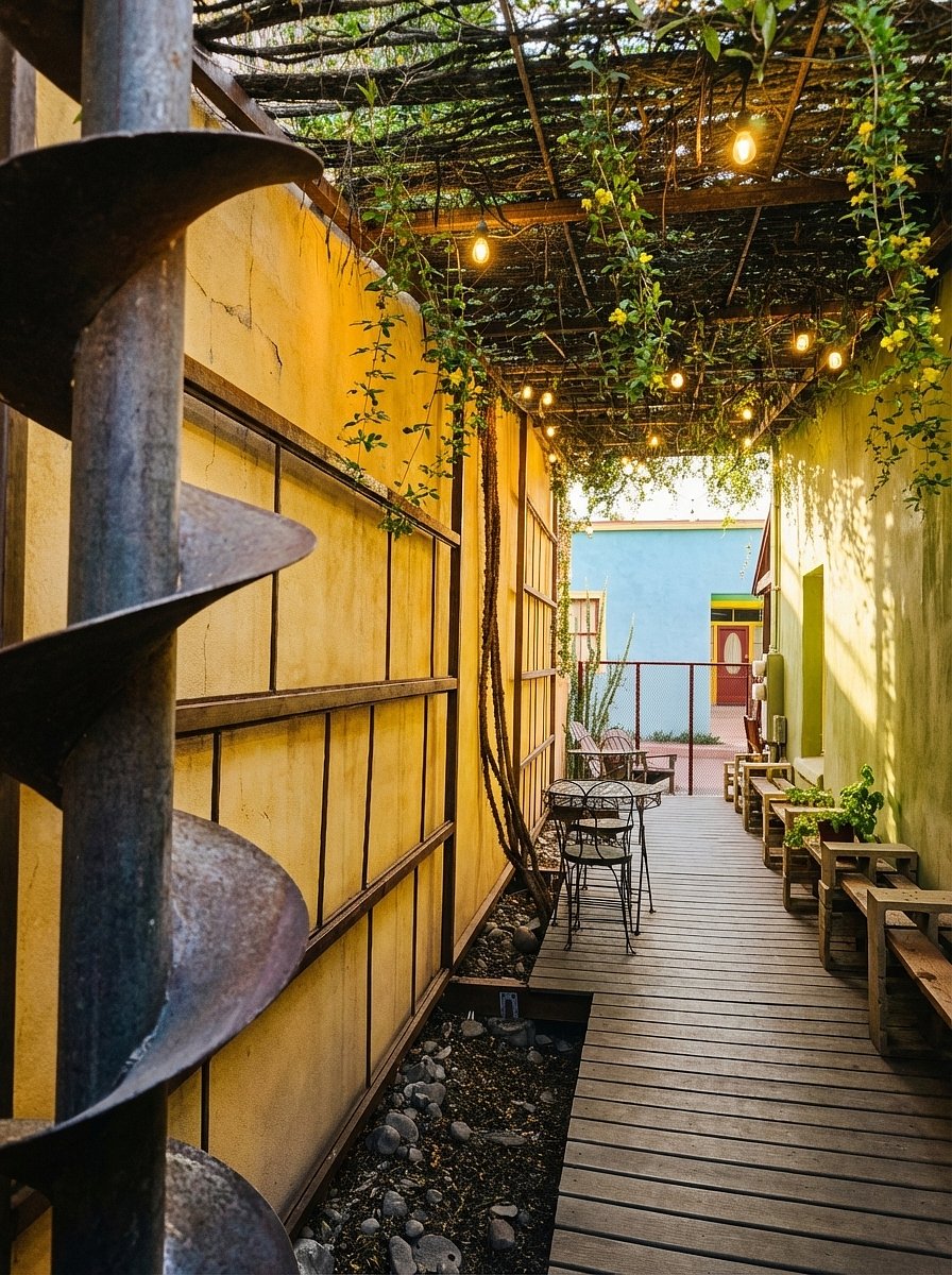 SIDE DECK WITH OCOTILLO-AND-STEEL RAMADA, AUGER DOWNSPOUT, AND GREYWATER-IRRIGATED CATCLAW
