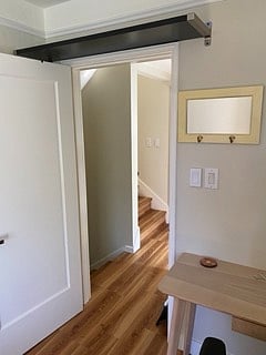 Looking out of your room, into the hallway. Bathroom is on the R in the hallway. The stairs take you down to the kitchen and living space.