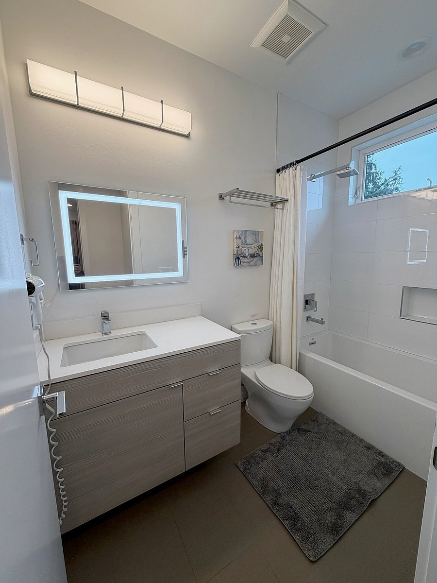 Full bathroom with illuminated mirror and modern finishes
