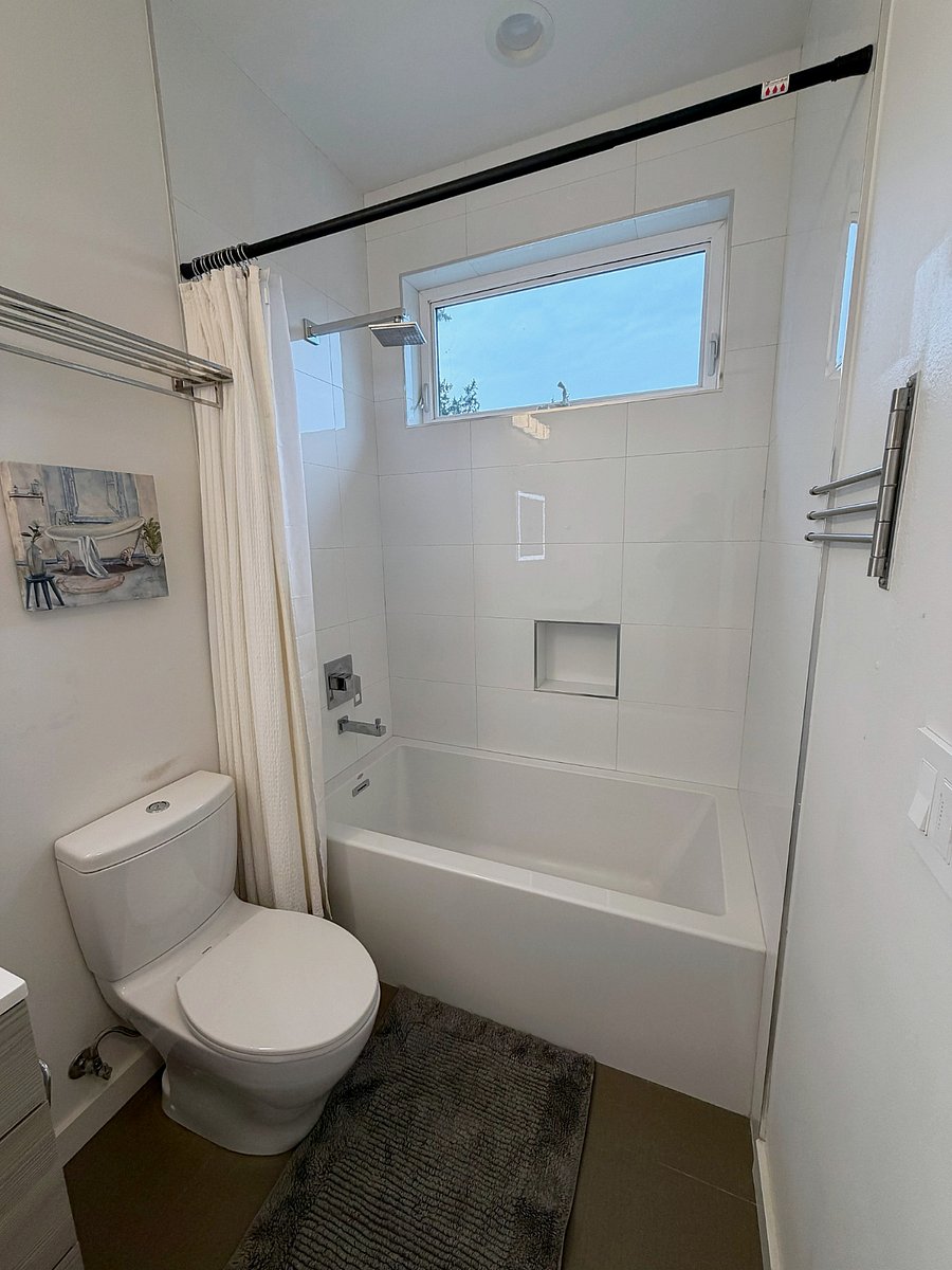 Tub and rain shower with tiled surround and built in niche