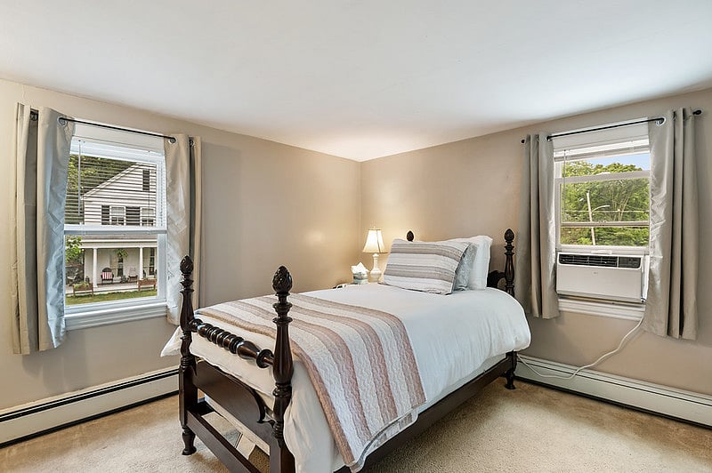 The second bedroom features a twin-size bed and an AC unit.