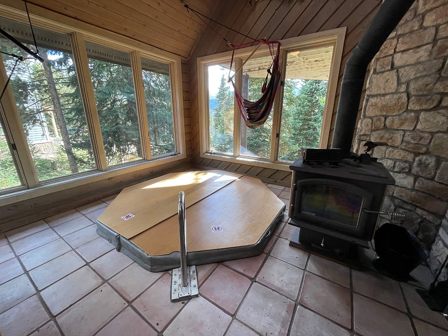 sunroom with indoor hot tub and wood burning fire