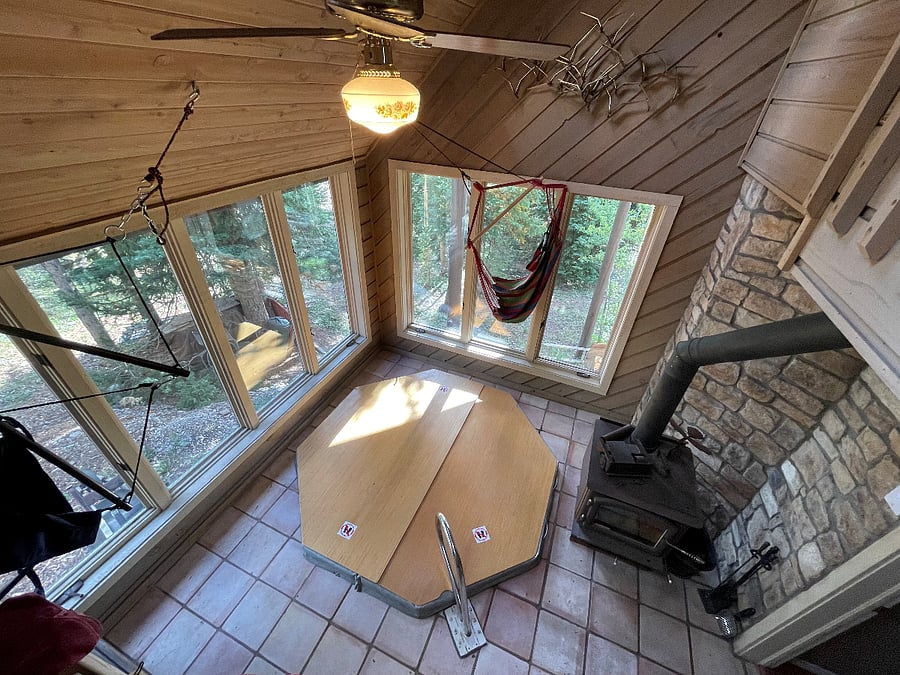 sunroom with indoor hot tub and wood burning fire