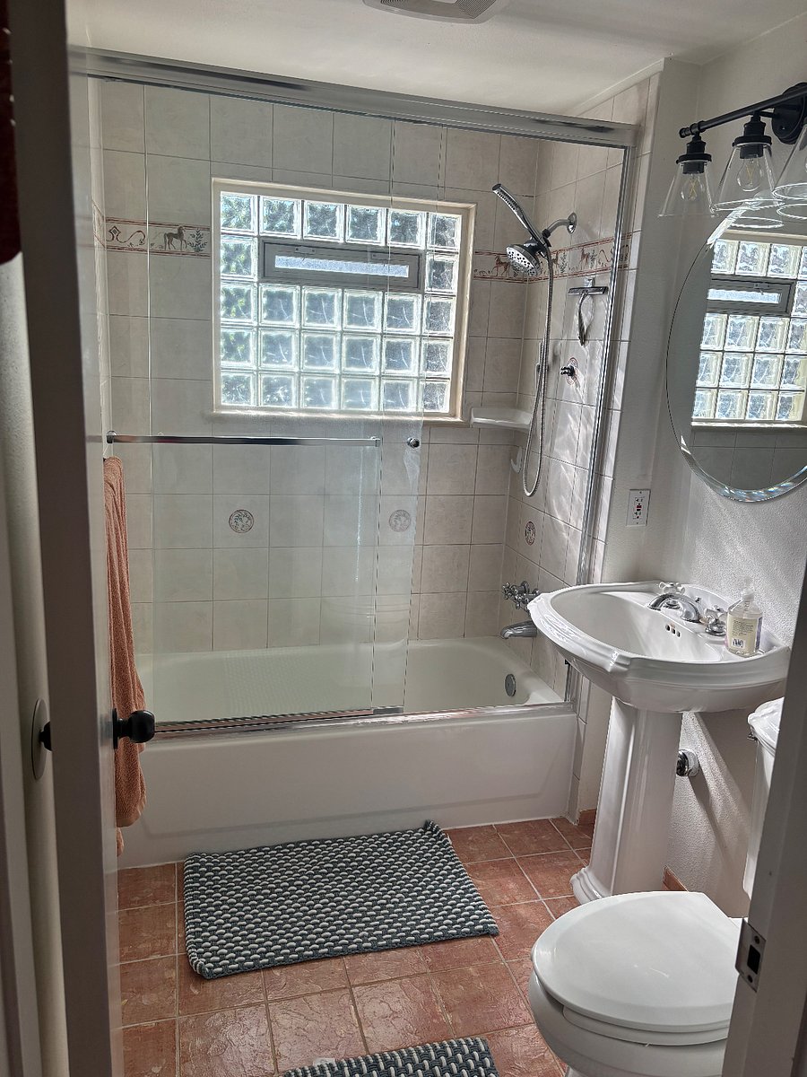 Bathroom has tiled tub and shower