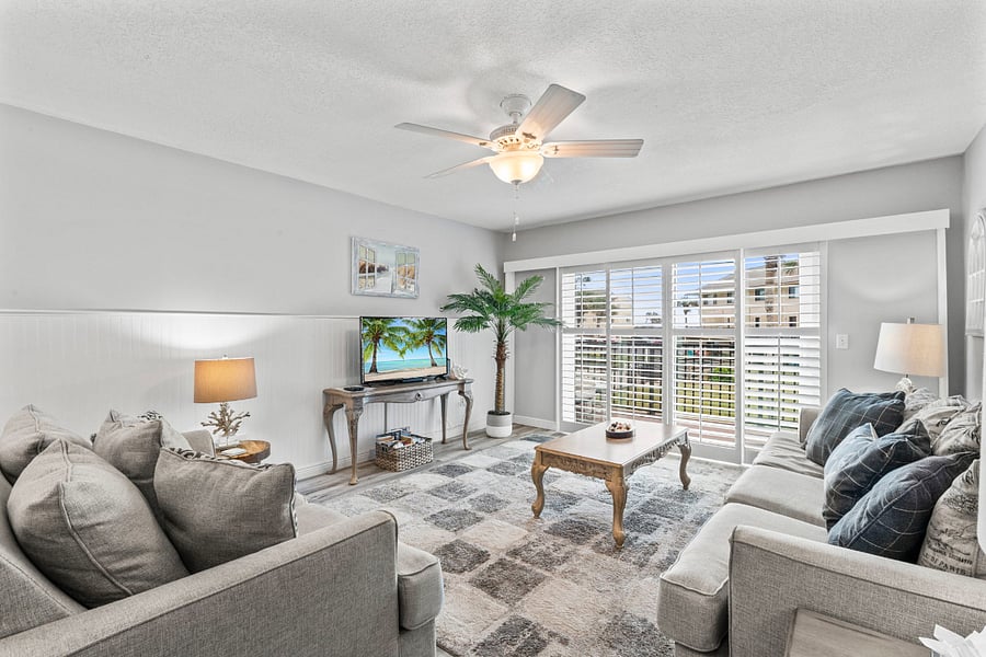 living room with TV and sliders to balcony