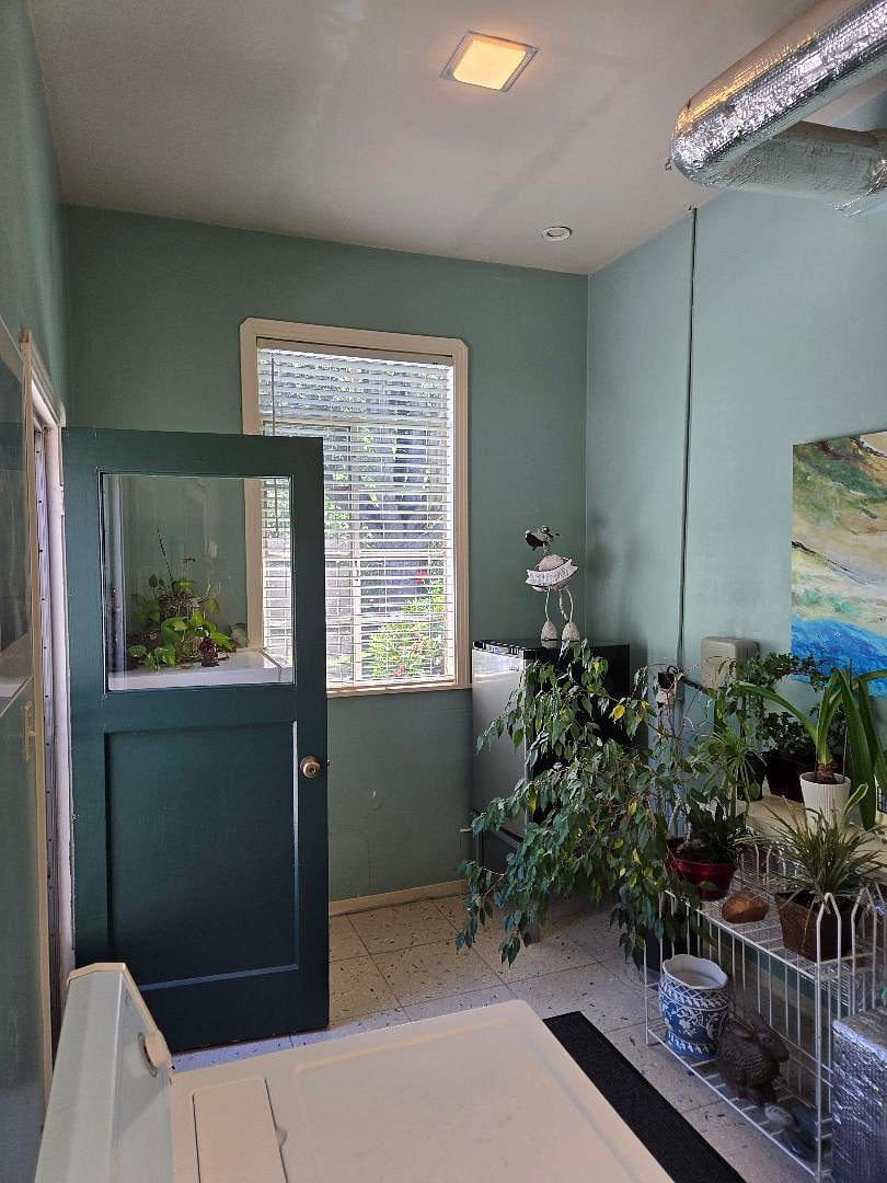 Semi-private entracne with grey refrigerator to the left of entrance