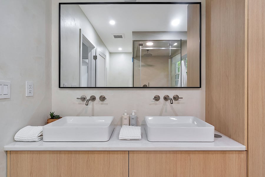 Mater bathroom vanity with white marble countertops and a double sink and Sonos speaker