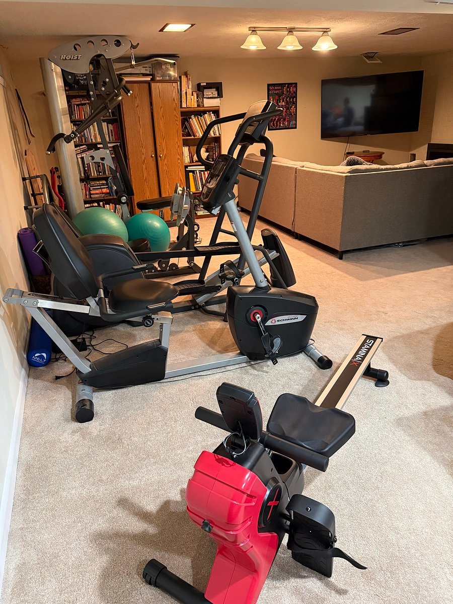 Exercise equipment in finished basement area-
Rowing machine, recumbent bike, elliptical, and home gym weights