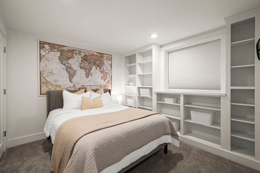Alternate bedroom angle highlighting built-in shelving, window black-out shades for cozy sleeping area.