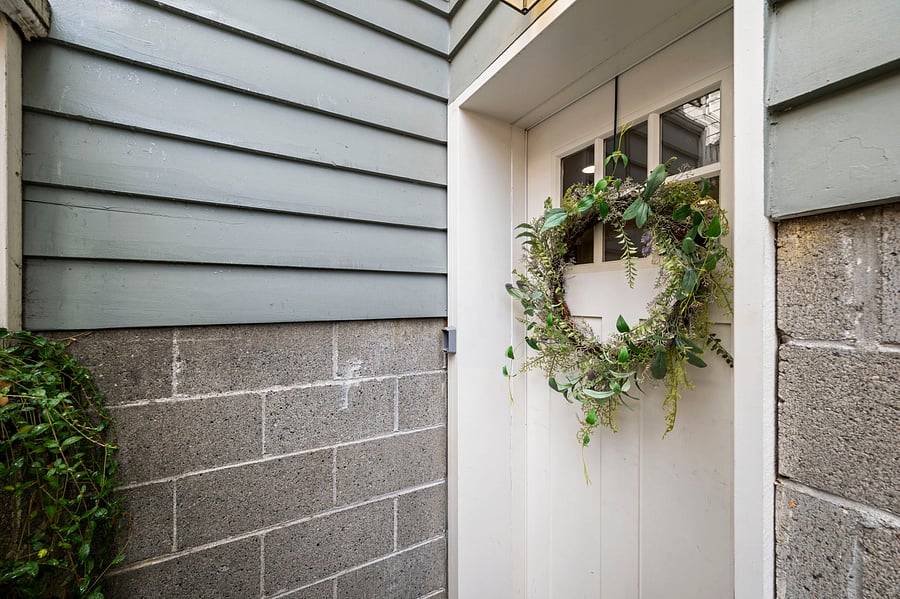 Private exterior basement entrance with wreath and direct access to the furnished unit.